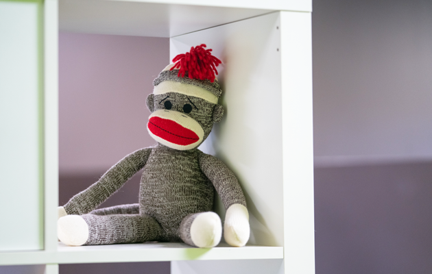 sock monkey sitting on shelf in office